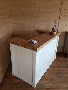 an empty room with wood paneling and a white counter top in the middle of it