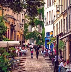 people are sitting at tables and walking down the street