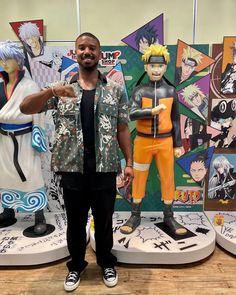 a man standing in front of some anime statues