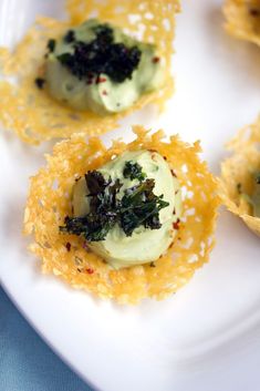 small appetizers on a white plate with cheese and herbs in them, ready to be eaten