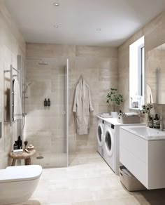 a washer and dryer in a bathroom with beige tile walls, flooring and white fixtures