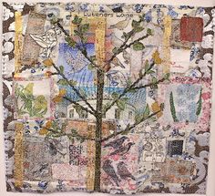 a tree with many pictures on it in the middle of a quilted wall hanging