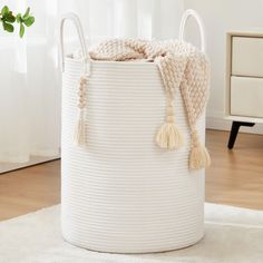 a large white basket with tassels on it