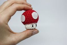 a hand holding a small crocheted mushroom