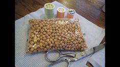 scissors and thread spools are sitting on a table next to a bag filled with beads