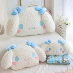 two stuffed animals sitting on top of a bed next to pillows and pillowcases