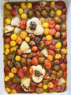 a white casserole dish filled with tomatoes, corn and brussel sprouts