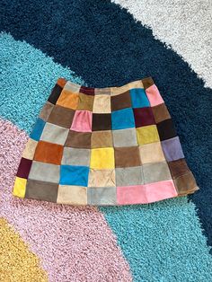 a multicolored rug is laying on the floor with it's end rolled up