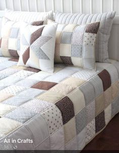 a bed with white and brown quilts on it