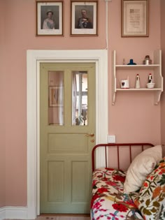 a bedroom with pink walls and pictures on the wall