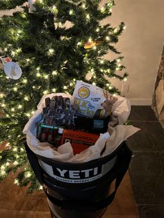 a christmas tree with lights in the background and a large bucket full of snacks sitting next to it