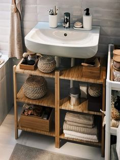 a bathroom sink sitting next to a wooden shelf