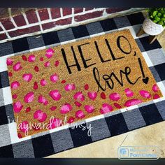 a welcome mat with the words hello love written in black and pink ink on it