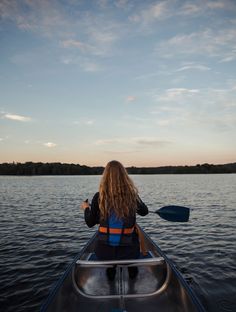 a woman sitting in a boat on the water