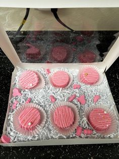 some pink frosted cupcakes in a box