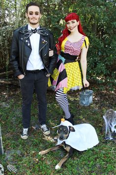 a man and woman in costumes standing next to a dog