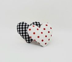 two heart shaped fabric pieces with red and black polka dots on the sides, one in the shape of a heart