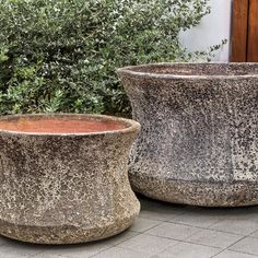 two cement planters sitting next to each other