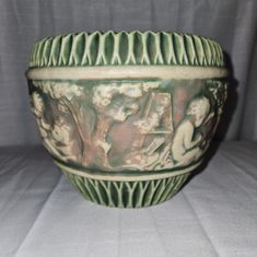 a green bowl sitting on top of a white table