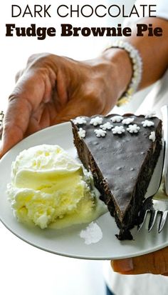 a piece of chocolate fudge brownie pie on a white plate with ice cream