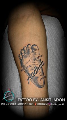 a tattoo on the arm of a person with a foot and name tattooed to it