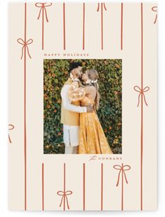 an orange and white card with a photo of two people holding each other in front of a