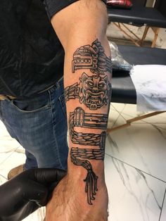 a man with a tattoo on his arm that has an image of a skeleton holding a car