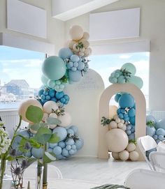 balloons and greenery decorate the entrance to a wedding reception at an ocean - themed venue