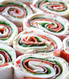 rolls filled with meat, cheese and spinach on top of each other in different colors