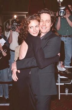 a man and woman hugging each other at an event