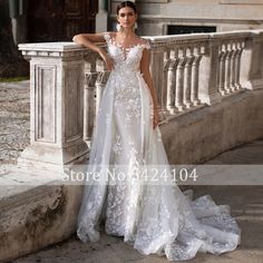 a woman in a white wedding dress standing on a balcony