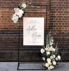 a sign that says welcome to the bride and groom with flowers in front of it