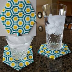 a glass with ice in it sitting on top of a table next to a coaster