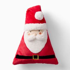 a red santa claus pillow sitting on top of a white wall