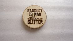 a wooden button with the words sandbust is man on it and an image of a tractor