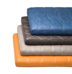 four different colored cushions stacked on top of each other