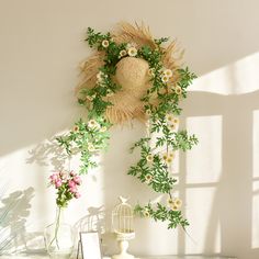 an arrangement of flowers and plants on a table in front of a wall mounted clock