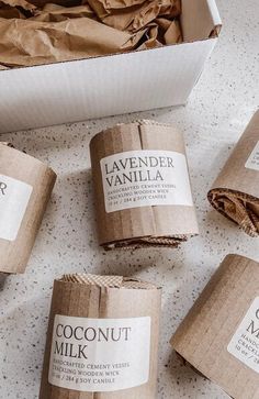 four rolls of coconut milk sitting on top of a counter next to some brown paper