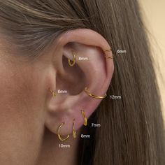 a woman's ear is shown with three different types of piercings