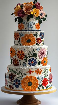 a multi - tiered cake decorated with colorful flowers