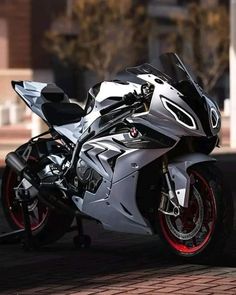 a silver motorcycle parked on top of a brick road