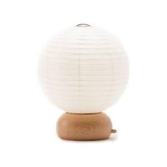 a white paper lantern sitting on top of a wooden stand