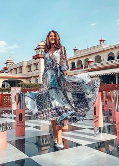 a woman standing on top of a checkered floor in front of a large building