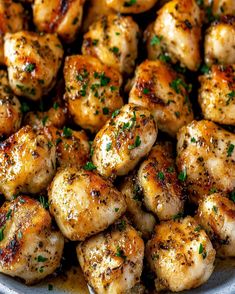 a plate full of chicken with parsley on the top and seasoning in the middle