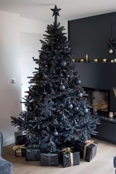 a black christmas tree with presents under it