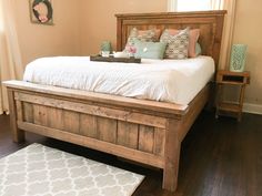 a bed with white sheets and pillows on top of it in a bedroom next to a window