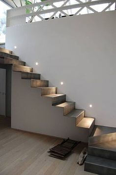 there is a set of stairs with lights on the bottom and below it in this modern house