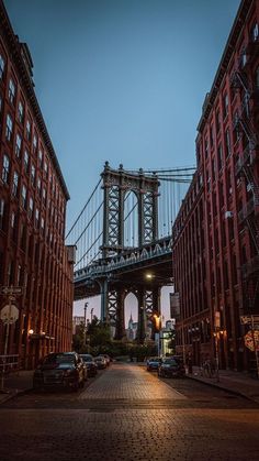 an image of a bridge going over the city at night time with cars parked on the street