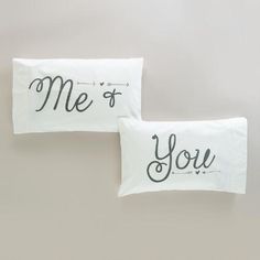 two white pillows with the words me and you printed on them sitting side by side