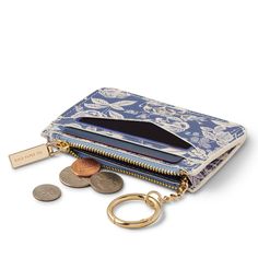 a purse with coins and a keychain on the front, sitting next to it